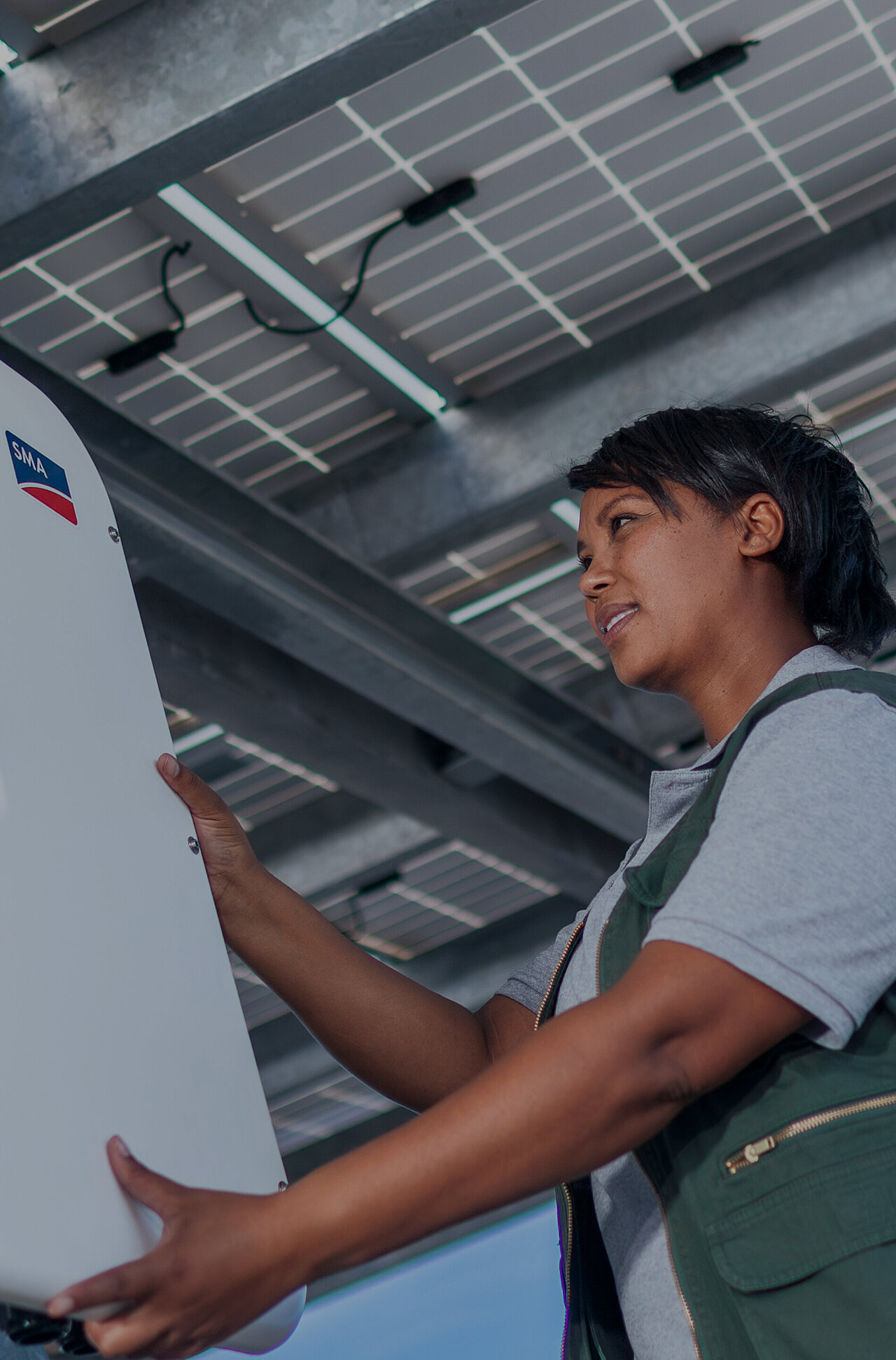 A female technician is working on an SMA inverter.